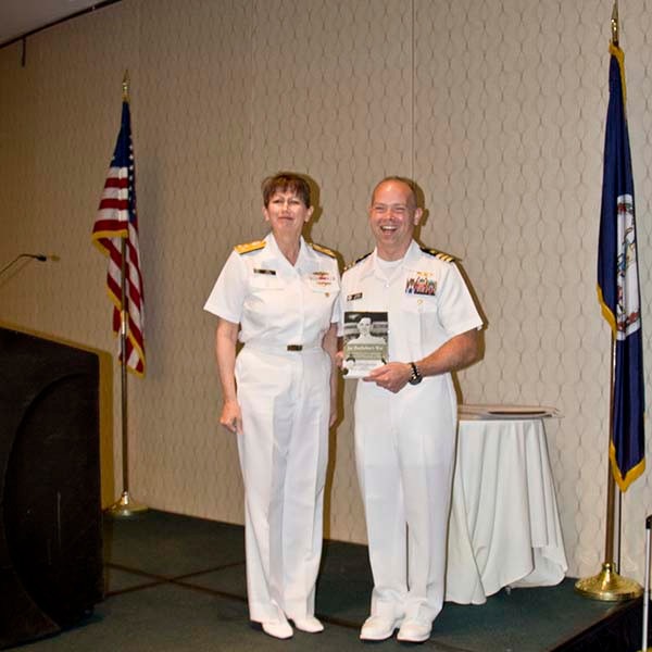 Presented to CDR Michael C. Elliot by VADM Tighe